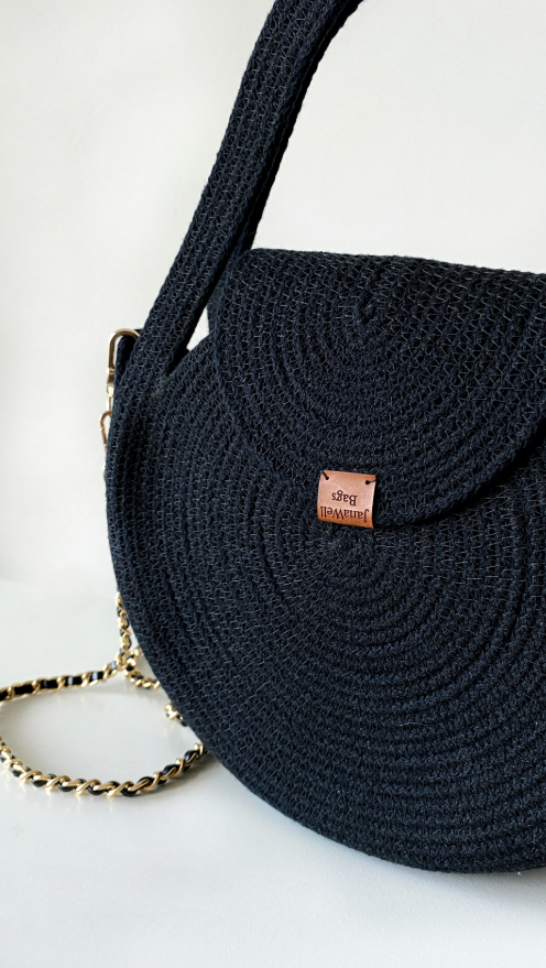 Mazā melnā rokassomiņa.